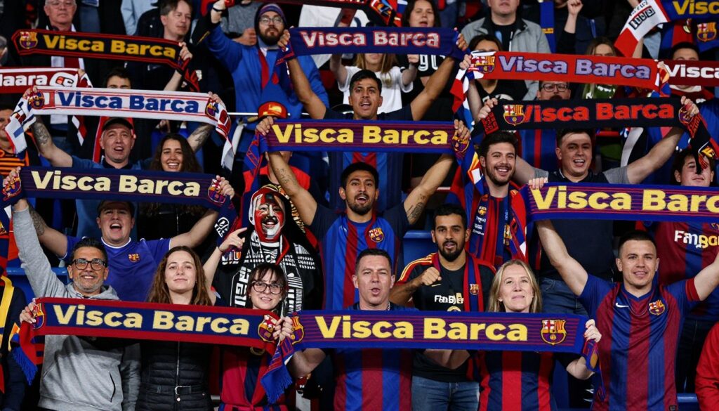 Międzynarodowi kibice FC Barcelona z różnych krajów trzymający szaliki z napisem 'Visca Barca'